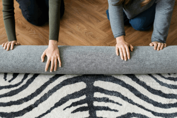 A picture of people rolling a carpet