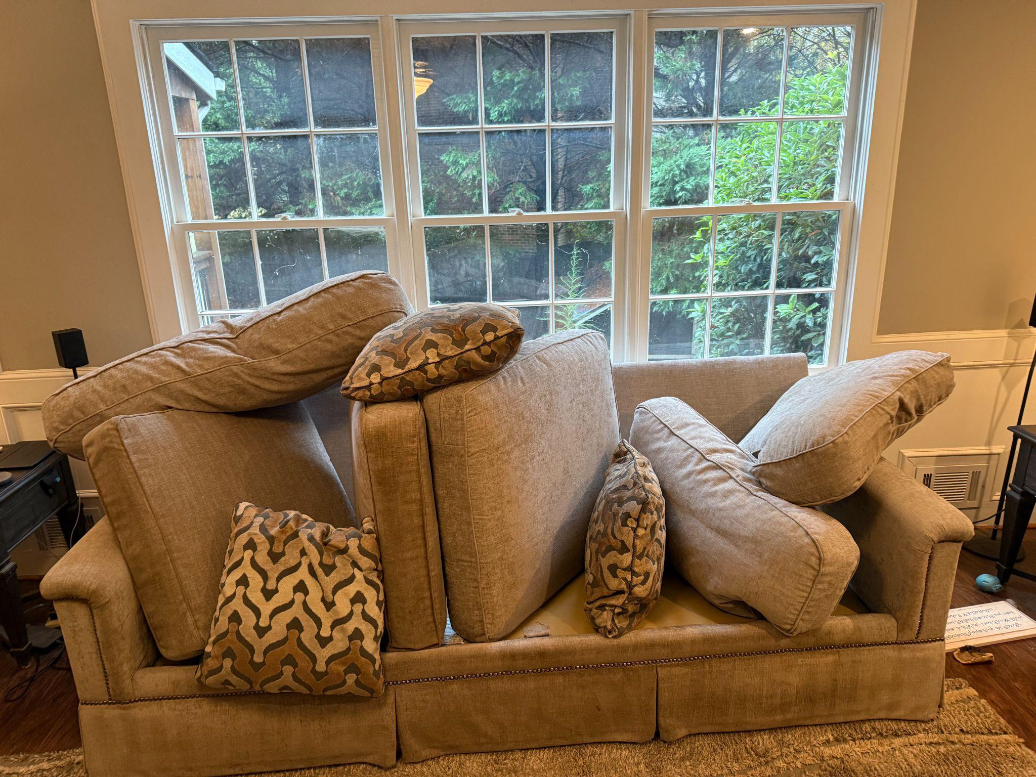 This photo shows a disheveled sofa in the middle of a room