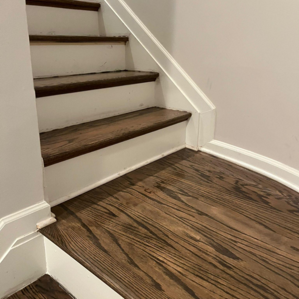 This photo shows stairs with hardwood flooring on them.