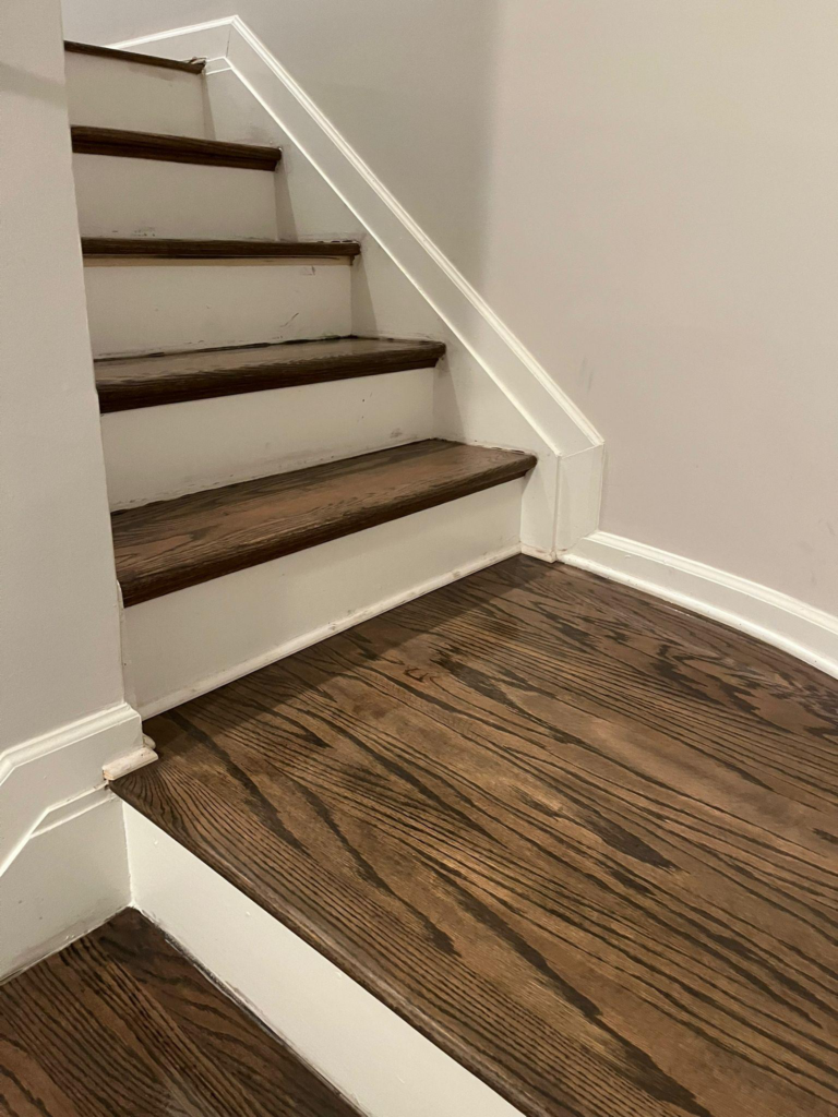 This photo shows stairs with hardwood flooring on them.